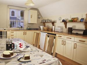 a kitchen with a table with a cake on it at 7 Glenthorne House in Salcombe
