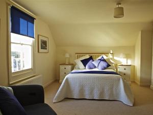 a bedroom with a bed with purple pillows and a window at 7 Glenthorne House in Salcombe