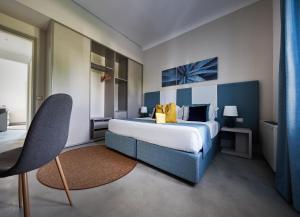 a bedroom with a blue and white bed and a chair at VOI Marsa Siclà Essentia in Sampieri