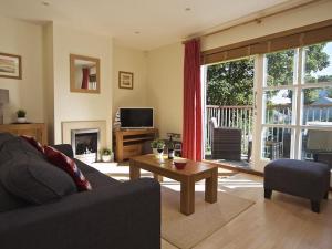 a living room with a couch and a table at 1 Combehaven in Salcombe
