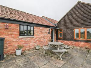 einem Picknicktisch vor einem Backsteingebäude in der Unterkunft Keepers Cottage in Warminster