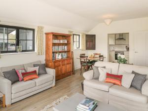 a living room with two couches and a table at Keepers Cottage in Warminster