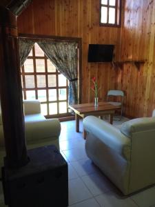 sala de estar con sofá y mesa en Cabañas Tornagaleones Villarrica, en Villarrica