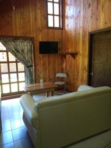 uma sala de estar com um sofá e uma mesa em Cabañas Tornagaleones Villarrica em Villarrica