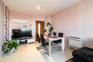 een woonkamer met een tafel met stoelen en een televisie bij BGApartments - Chataldzha in Varna