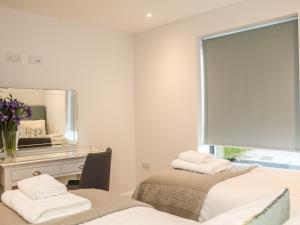 a white room with two beds and a mirror at Little Fistral in Newquay