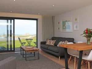 a living room with a couch and a table at Little Fistral in Newquay