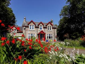 a house with red flowers in front of it at Roseburn in Pitlochry