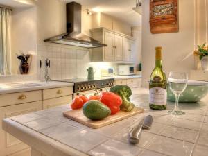 a kitchen with a counter with a bottle of wine and vegetables at Parnacott in Pancrasweek