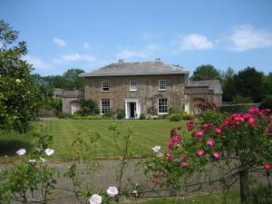 an old stone house with flowers in front of it at Parnacott in Pancrasweek