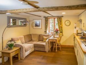 a living room with a couch and a table at Weir Cottage in Maidstone
