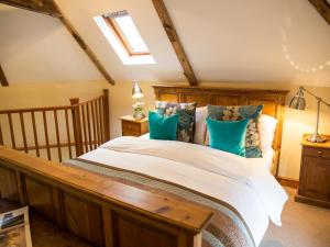 a bedroom with a large bed with blue pillows at Weir Cottage in Maidstone