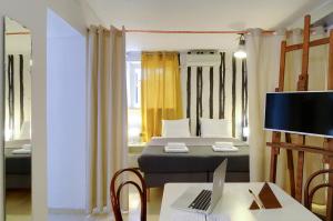 een kamer met een bed en een bureau met een laptop bij Athens Green Apartments in Athene