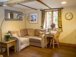ein Wohnzimmer mit Sofa und Tisch in der Unterkunft Weir Cottage in Maidstone