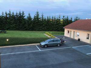 a car parked in a parking lot next to a house at Villa Motel in Stenay