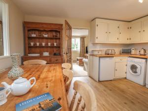 a kitchen and dining room with a wooden table at The Oast in Maidstone +8 photos