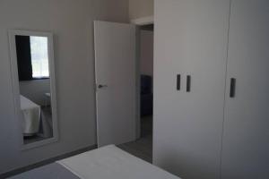 um quarto branco com uma porta e um espelho em Apartamentos los Acantilados Nº 1 Cobreces em Cóbreces