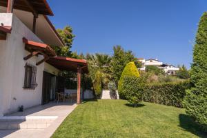 a backyard of a house with a green yard at Villa Katerina in Siviri