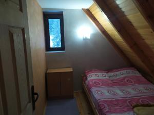 ein kleines Bett in einem Zimmer mit Fenster in der Unterkunft Vila Balerina in Mitrovac