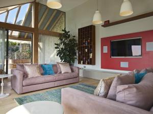 a living room with two couches and a flat screen tv at Woodwell in Salcombe