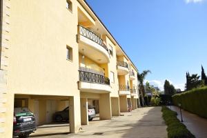 a large apartment building with cars parked on a sidewalk at Raise Cosy Studio with pool in Limassol in Limassol