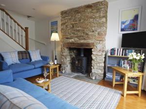 a living room with a blue couch and a stone fireplace at Armada Cottage in Dartmouth