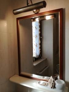 un espejo sobre un lavabo en el baño en La dimora degli Artisti en Foggia
