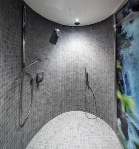Ferienhotel Tyrol Söll am Wilden Kaiser في سول: دش في حمام مع أرضية من البلاط