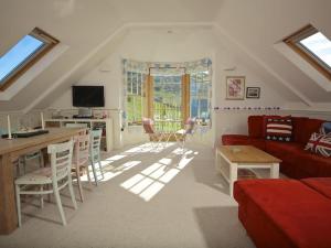 a living room with a red couch and a table at 9 Prospect House in Kingsbridge