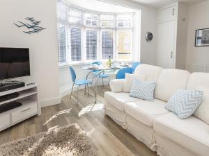uma sala de estar com um sofá branco e uma mesa em The Apartment, Newcomen Road em Dartmouth