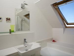 a white bathroom with a sink and a window at 9 Prospect House in Kingsbridge +16 photos