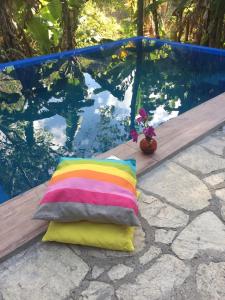 a colorful pillow sitting next to a swimming pool at Sitio Alto da Montanha - você em paz com a natureza in Pacoti