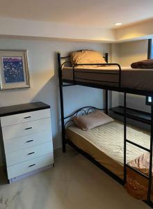 Jomtien Beach Hostel & Guesthouse في جومتين بيتش: غرفة نوم مع سريرين بطابقين وخزانة