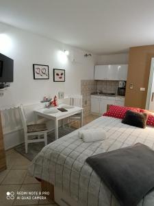 a bedroom with two beds and a table and a kitchen at Apartments Vrime in Biograd na Moru