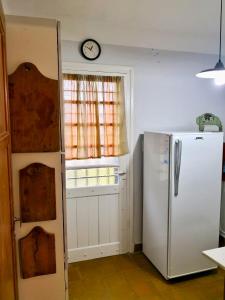 eine Küche mit einem Kühlschrank und einer Uhr an der Wand in der Unterkunft Casa en Villa Amancay in Amboy