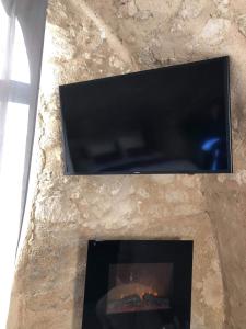 chimenea con TV y chimenea en Paradise Love In Provence - loft en pierres - spa privatif, en Reillanne