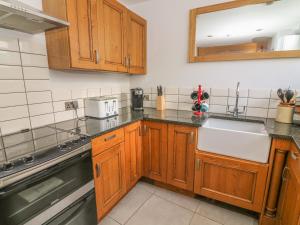 a kitchen with wooden cabinets and a sink at Flat 2 Galloway House in Kendal