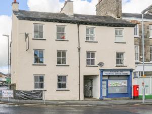 un vecchio edificio bianco con una porta blu su una strada di Flat 2 Galloway House a Kendal