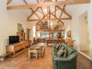 a living room with a couch and a table at The Barn in Honiton
