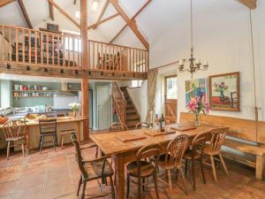 cocina y comedor con mesa de madera y sillas en The Barn en Honiton