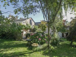 a garden with a tree and some flowers and a house at The Barn in Honiton