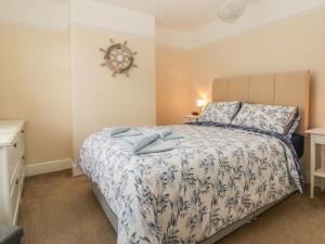 a bedroom with a bed with a blue and white bedspread at Sunvale in Teignmouth