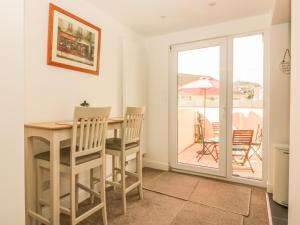 a dining room with a table and chairs and a balcony at Sunvale in Teignmouth
