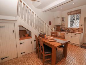 una cocina con una mesa de madera y una escalera en Laburnum Cottage, en Castleton