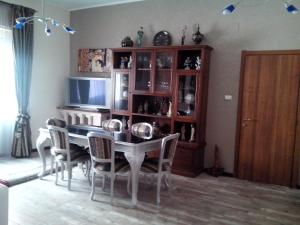 uma sala de jantar com uma mesa e cadeiras e uma televisão em Apartment i viaggi di Mario em Cagliari