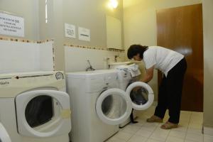 een vrouw in een badkamer die in een toilet kijkt bij Hotel Ankara Suites in Salta