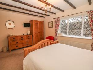 1 dormitorio con 1 cama, vestidor y ventana en Laburnum Cottage, en Castleton