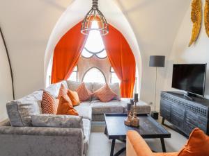a living room with a couch and a tv at Penthouse St Mary's Church in Moffat