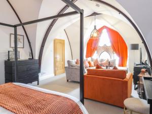 a bedroom with an arched ceiling with a bed and a couch at Penthouse St Mary's Church in Moffat
