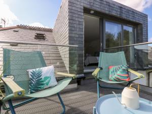 - une terrasse avec 2 chaises et une table dans l'établissement The Upper Deck, à Penzance